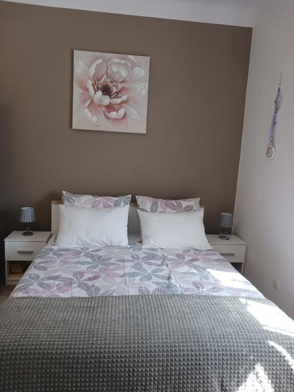 奥帕提亚Studio Luna的卧室配有一张挂有花卉画的床铺。