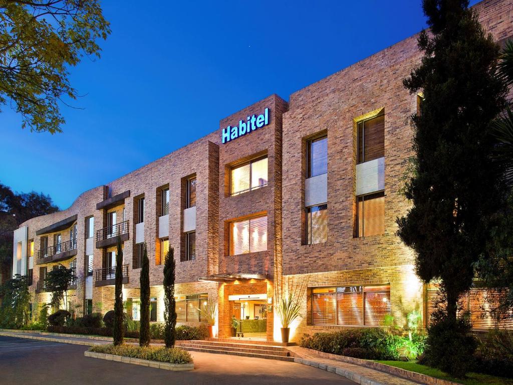 波哥大Hotel Habitel Select的砖砌建筑,上面有酒店标志