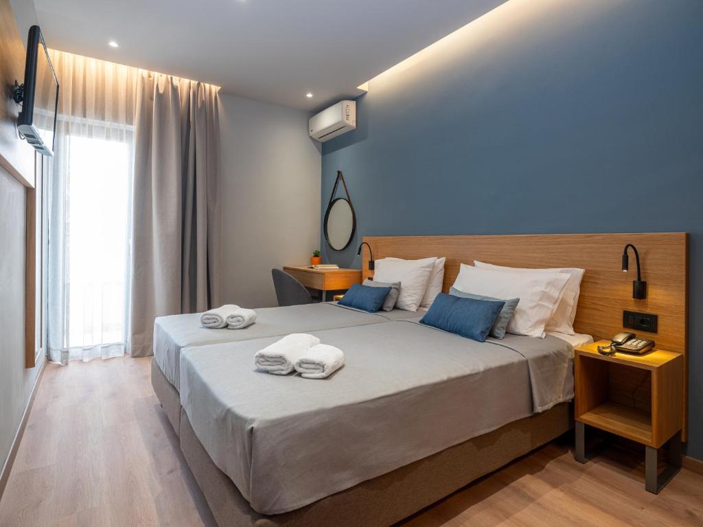 海若克利欧阿西恩尼克酒店的一间卧室配有一张大床和毛巾
