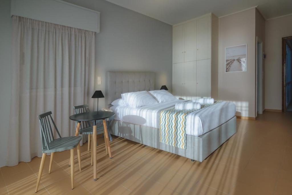 KatarráktisCHIOS HOTEL的卧室配有一张床和一张桌子及椅子