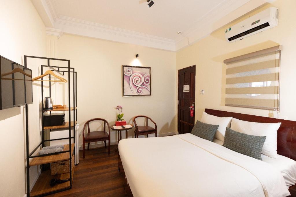 胡志明市9 Hostel and Suites的卧室配有一张床和一张桌子及椅子
