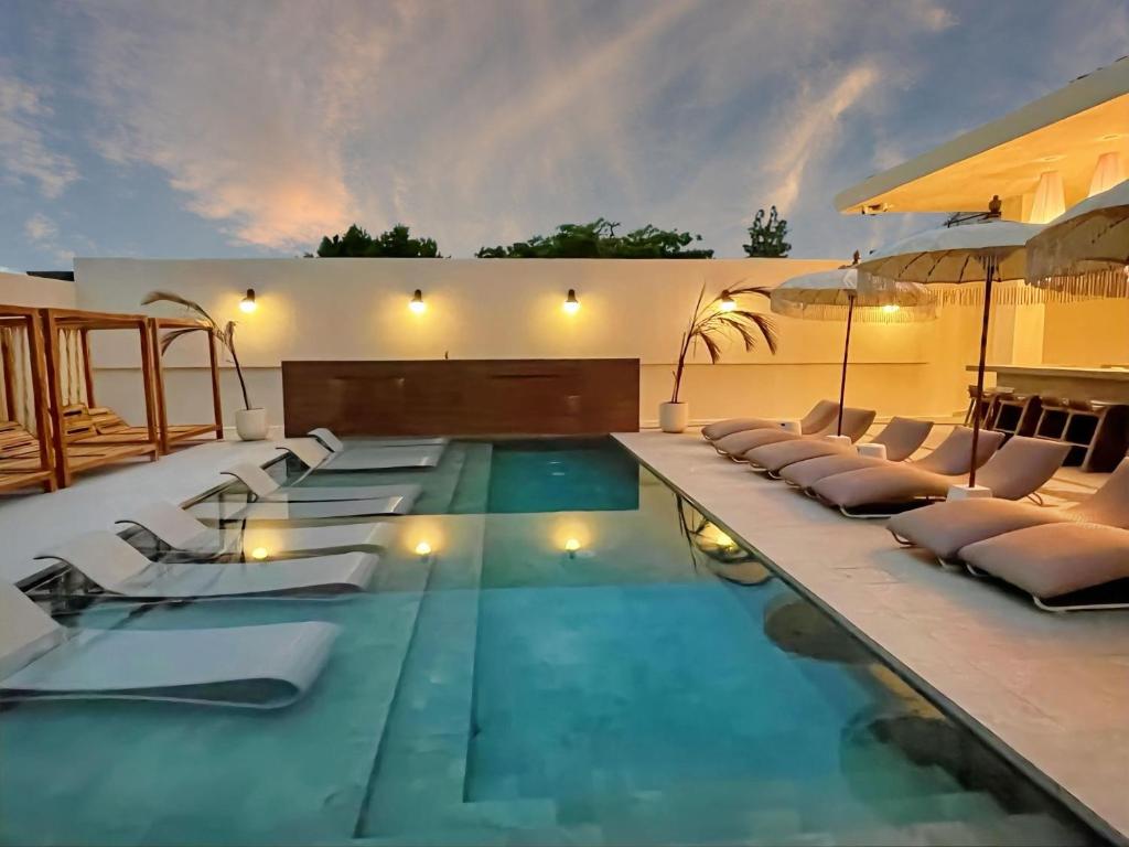 圣胡安Bali Poshtel PR的一个带躺椅的游泳池和一个游泳池