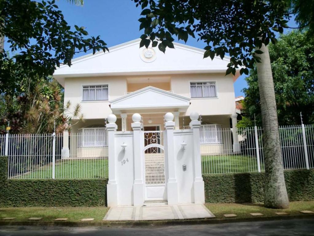 阿蒂巴亚Condomínio Dona Cida - Flats, Casas e kitnets Mobiliadas的前面有标志的白色房子