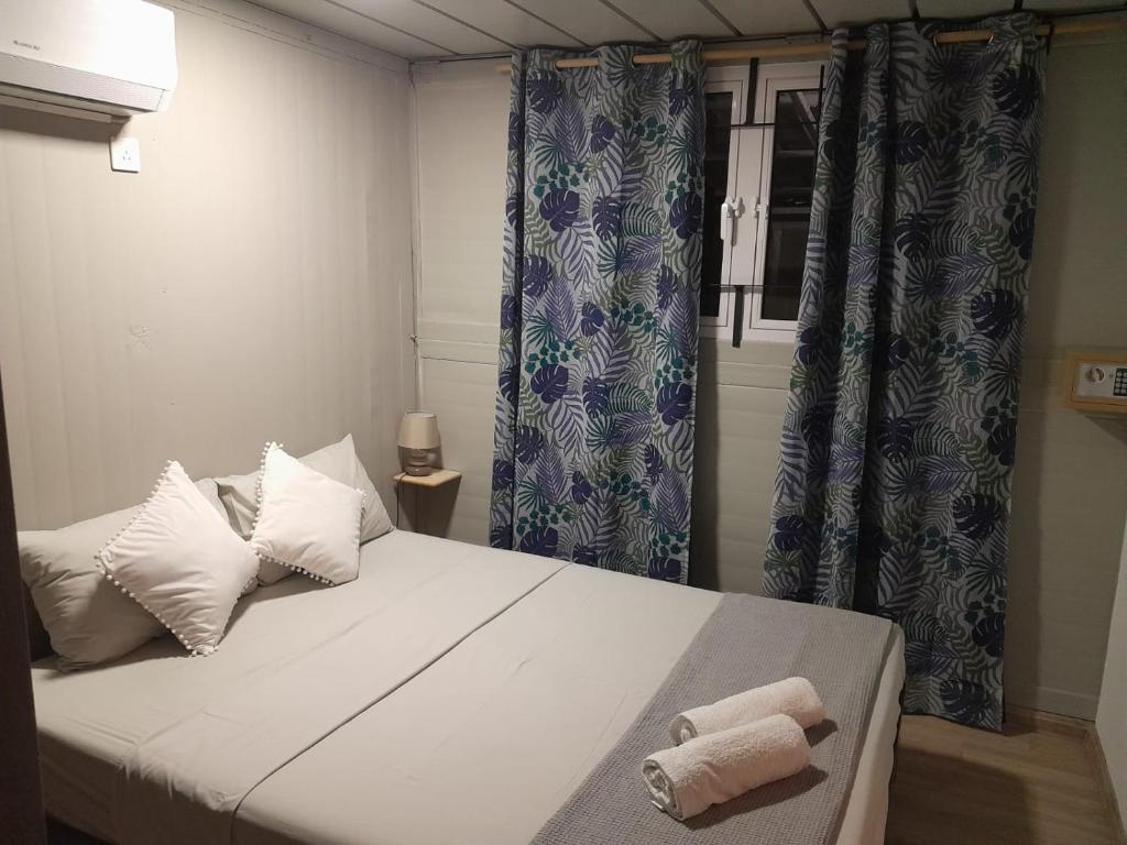 埃斯尼角Tilakaz Kreol的卧室配有一张带蓝色窗帘的大型白色床