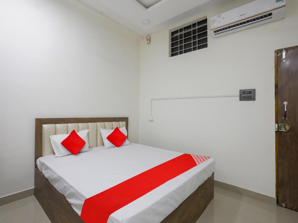 那格浦尔OYO Flagship Hotel Rahul Service Appartment 2的一间卧室配有红色和白色枕头的床
