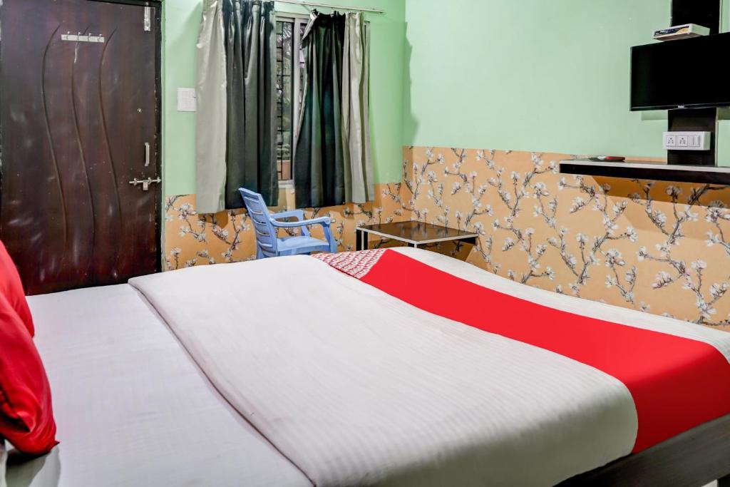 PhundardihHotel Welcome Sri Vip Road Raipur的一间卧室配有一张带红白毯子的床