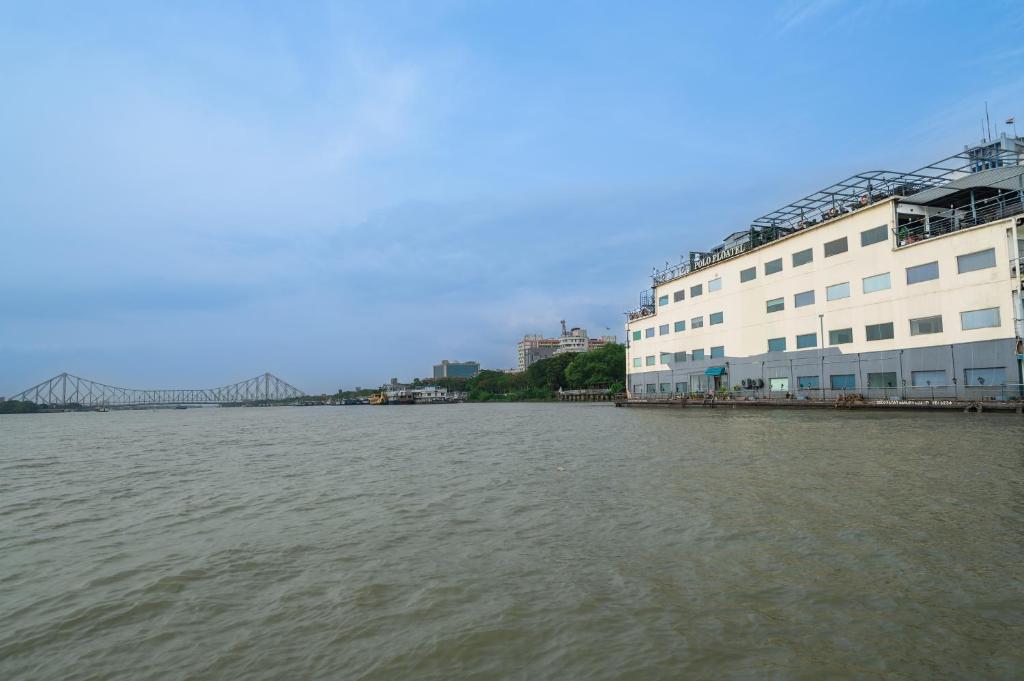 加尔各答Polo Floatel Kolkata的享有河流美景,设有一座建筑和一座桥梁
