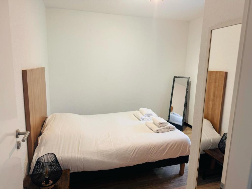 圣阿沃尔德KOSY Appart'Hôtel 7ème Art的一间小卧室,配有一张床和镜子