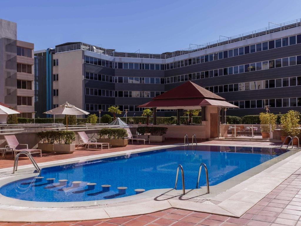马德里铂尔曼马德里机场展会酒店的大楼前的大型游泳池
