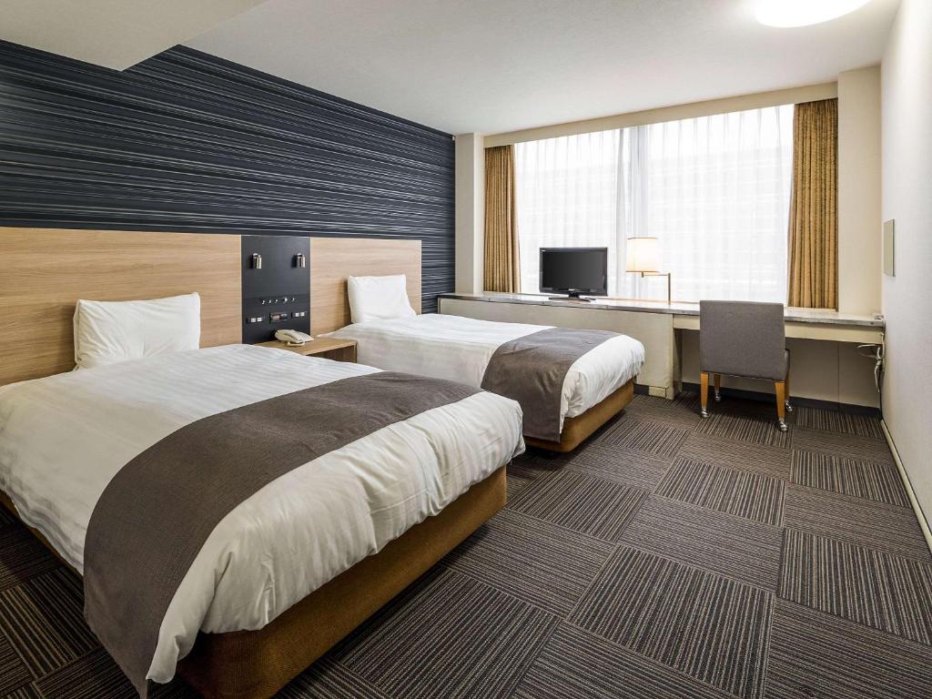 福冈博多舒适酒店的酒店客房配有两张床和一张书桌