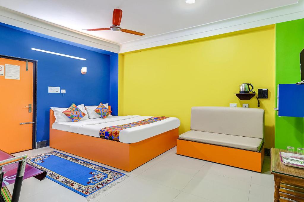 BāghdograFabHotel Relax的一间卧室拥有色彩缤纷的墙壁,配有一张床和椅子