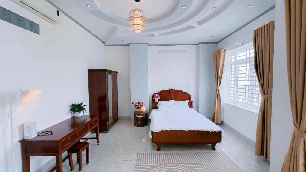 芹苴Miha Villa Can Tho的一间卧室配有一张床、一张桌子和一张四柱床。