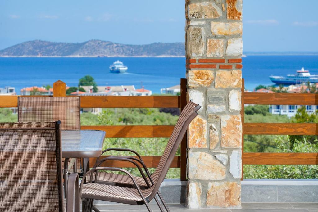 萨索斯Helicon Luxury Villas的海景阳台上的桌椅