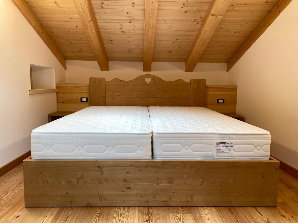 Le GrazieChalet Le Grazie的一间卧室配有一张木床架上的床垫