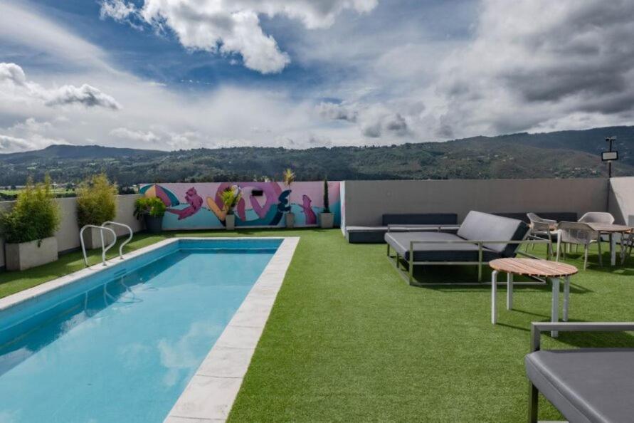 奇亚UMA Suites Chia的后院设有游泳池和绿草