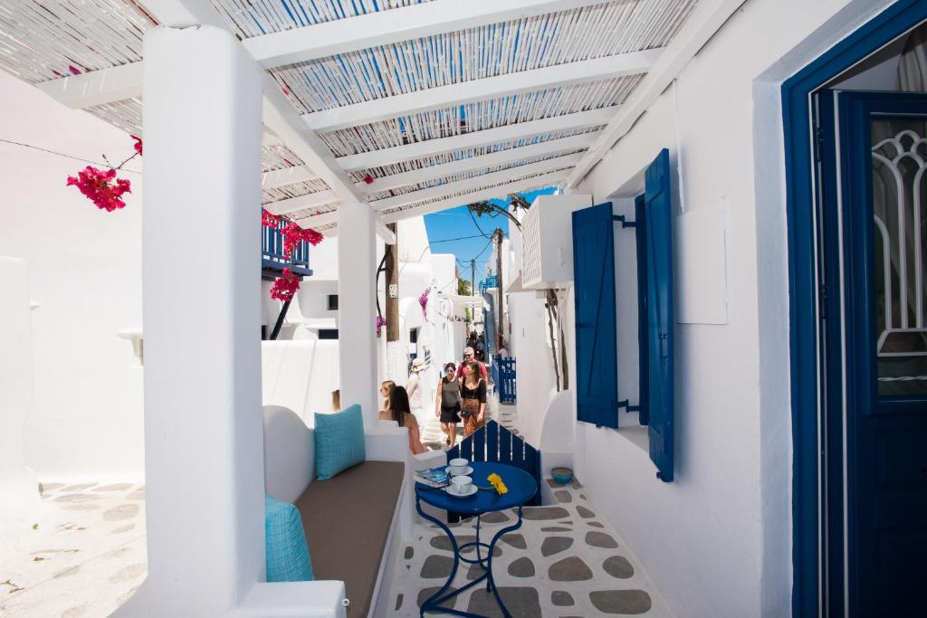 米克诺斯城Eleanna's Mykonos的白色建筑中带蓝色门和桌子的走道