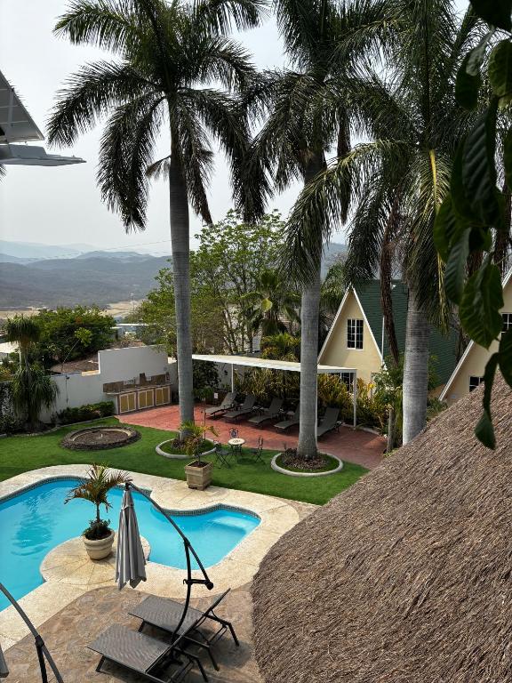 加尔潘VILLAS EL ENCANTO的一个带游泳池和棕榈树的度假村