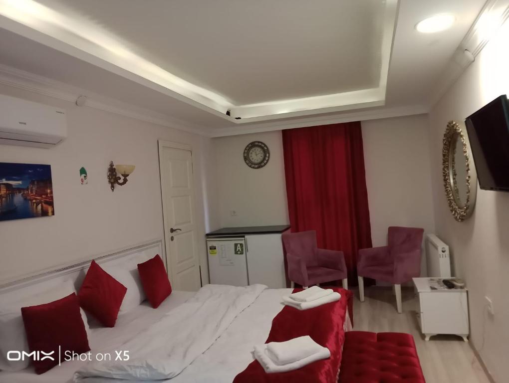 特拉布宗ÇARŞI HOTEL&CAFE的酒店客房,配有床铺和红色椅子