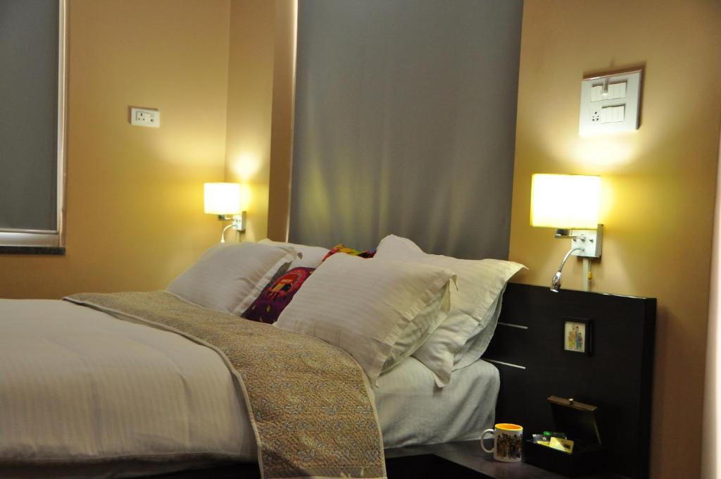 阿杰梅尔Shardas Homestay的一间卧室配有一张带白色枕头的床和两盏灯。