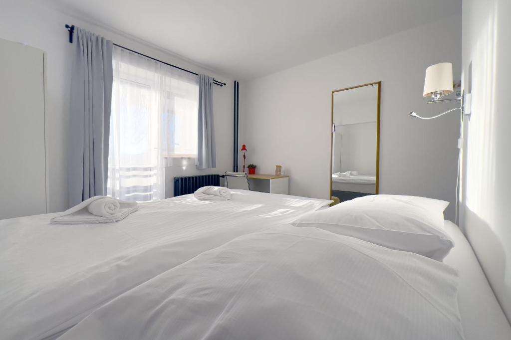 什平德莱鲁夫姆林霍尔尼普拉姆酒店的白色的卧室设有白色的床和窗户。