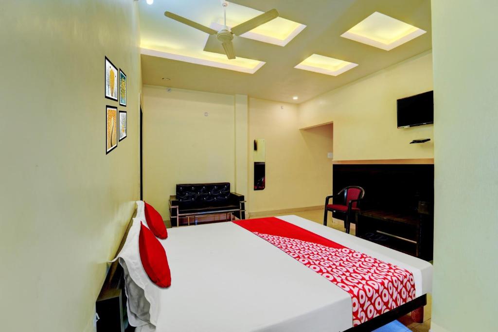 ChupraOYO Flagship Hotel Centre Point的卧室配有一张带红色毯子的白色床