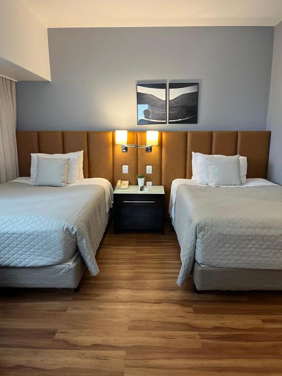 圣保罗Suite 505 Wynd Berrini WTC - SP的酒店客房设有两张床和一张桌子。