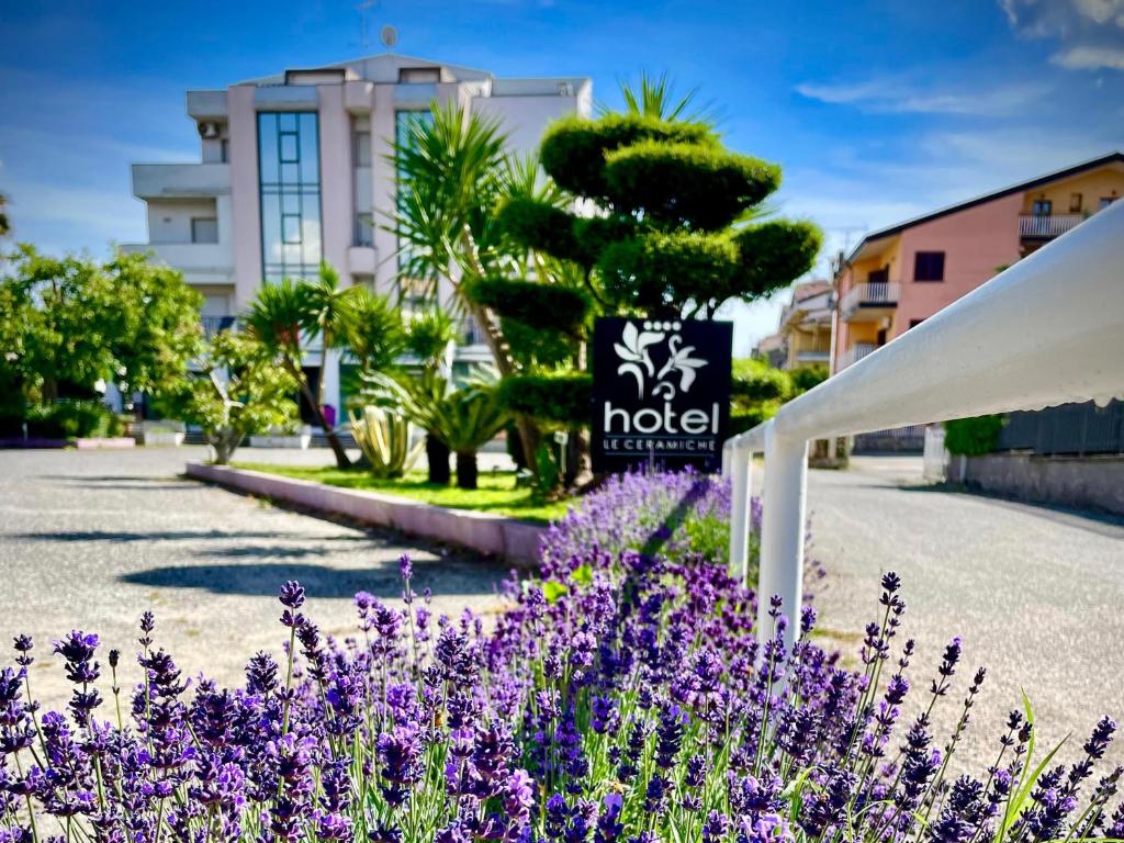 蒙塔尔图富戈Le Ceramiche - Hotel Residence ed Eventi的一座花园,在酒店的前面种有紫色花朵