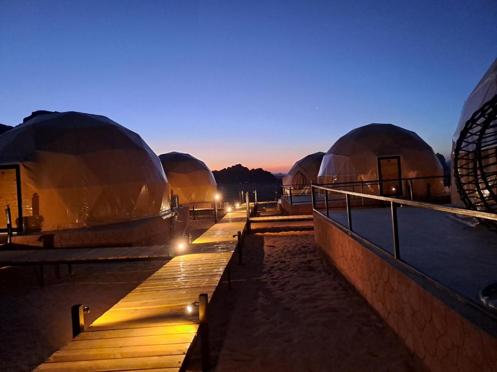 瓦迪拉姆Taj Wadi Rum camp的海滩上一排灯火的圆顶建筑