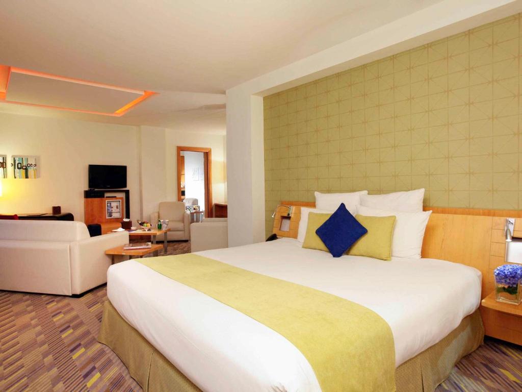 达曼达曼商业园诺富特酒店的一间带大床的卧室和一间客厅