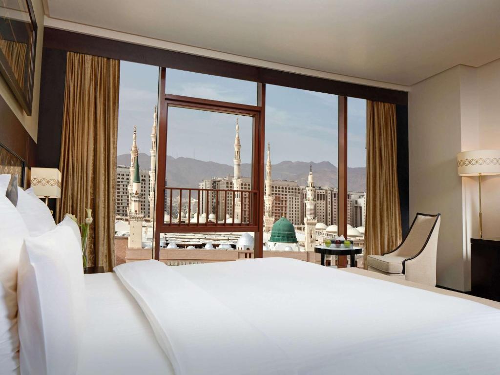 麦地那麦地那普尔曼扎姆扎姆酒店的卧室设有一张白色大床和大窗户