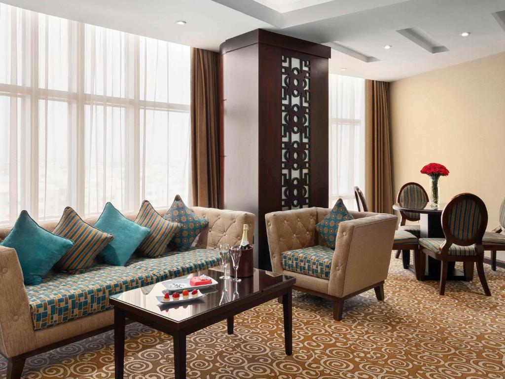 布赖代卡西姆瑞享酒店的客厅配有沙发、椅子和桌子