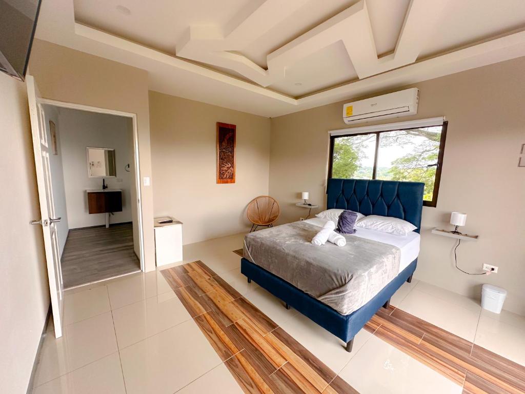 Santiago EsteCasa Garitas GuestHouse - Free SJO Airport Shuttle的一间卧室设有蓝色的床和窗户。