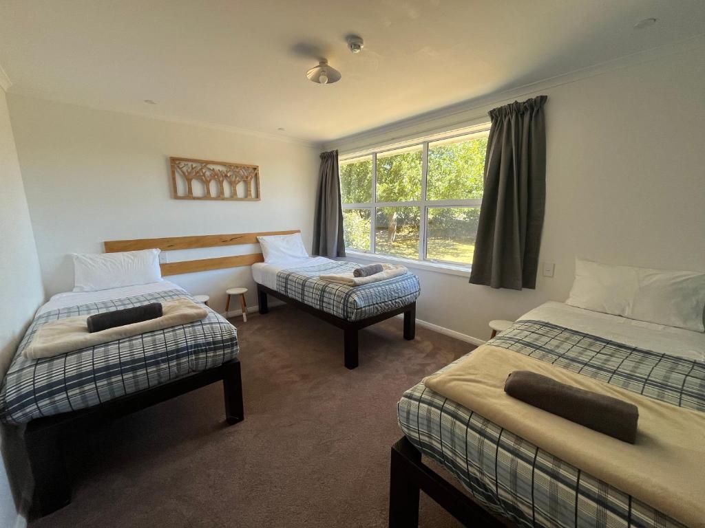 特卡波湖Tailor Made Tekapo Accommodation - Guesthouse & Hostel的客房设有两张床和窗户。