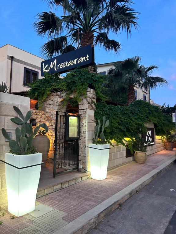 圣维托罗卡波Krimar Hotel的餐厅的入口,有门和植物