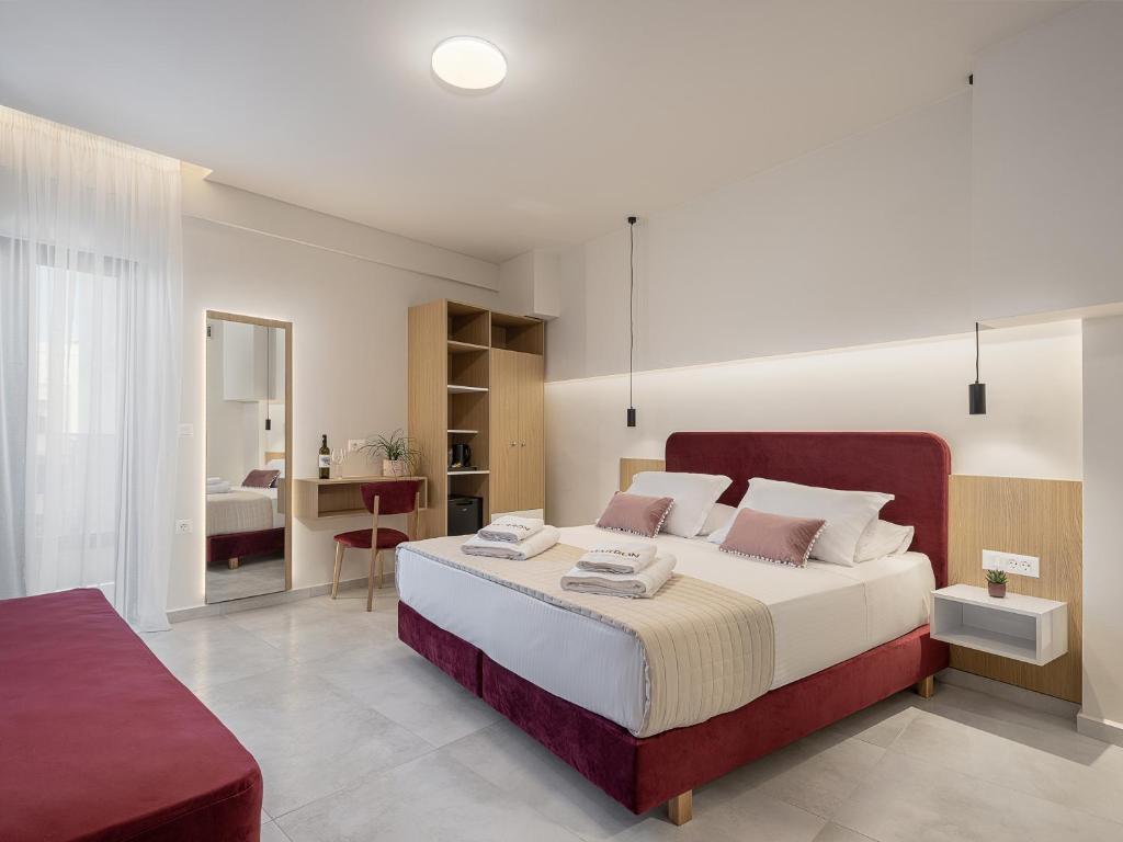 干尼亚Marron Lifestyle Hotel的一间卧室配有一张大床和红色床头板