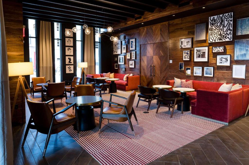 萨默维尔Cambria Hotel Boston Somerville的大堂设有桌子、沙发和椅子。