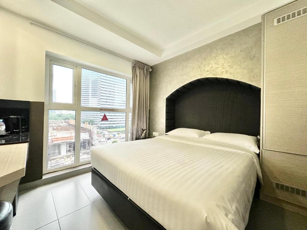 新加坡The Snooze Hotel at Bugis的一间卧室设有一张大床和一个大窗户