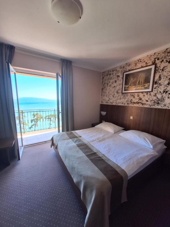 沃洛斯科VILLA VOLOSKO with private parking and breakfast,seaview的一间卧室设有一张大床和大窗户