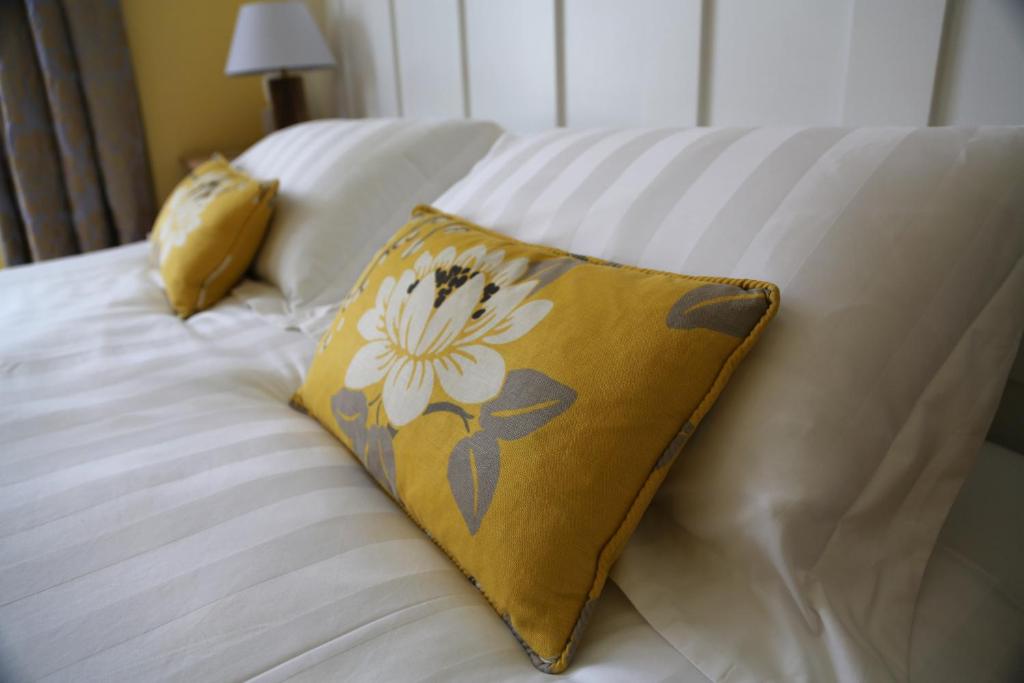 考斯冬青树住宿加早餐旅馆的一张带黄色枕头的床,上面有花