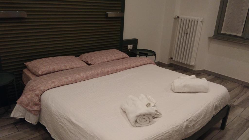 都灵Suite White的一间卧室配有带毛巾的床