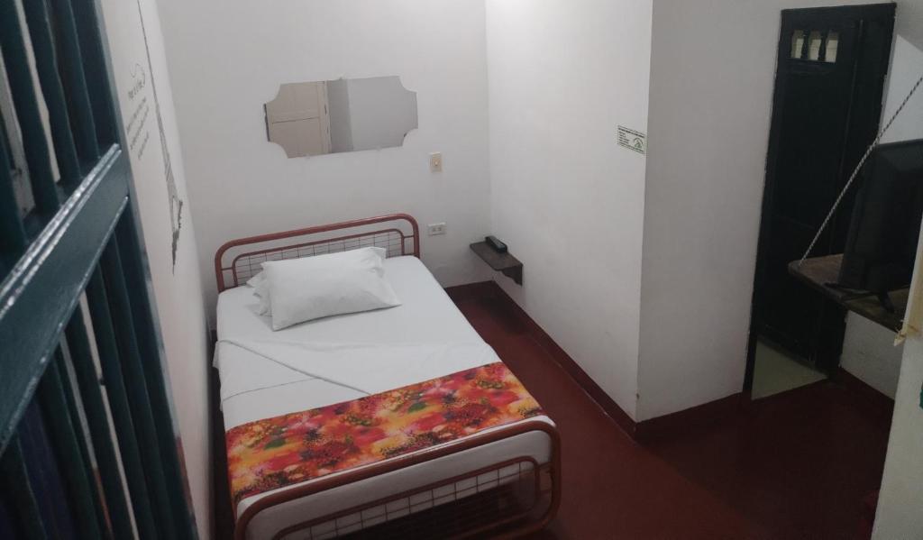 瓜杜阿斯Hostel La Casona 1859的小房间,房间内设有一张小床