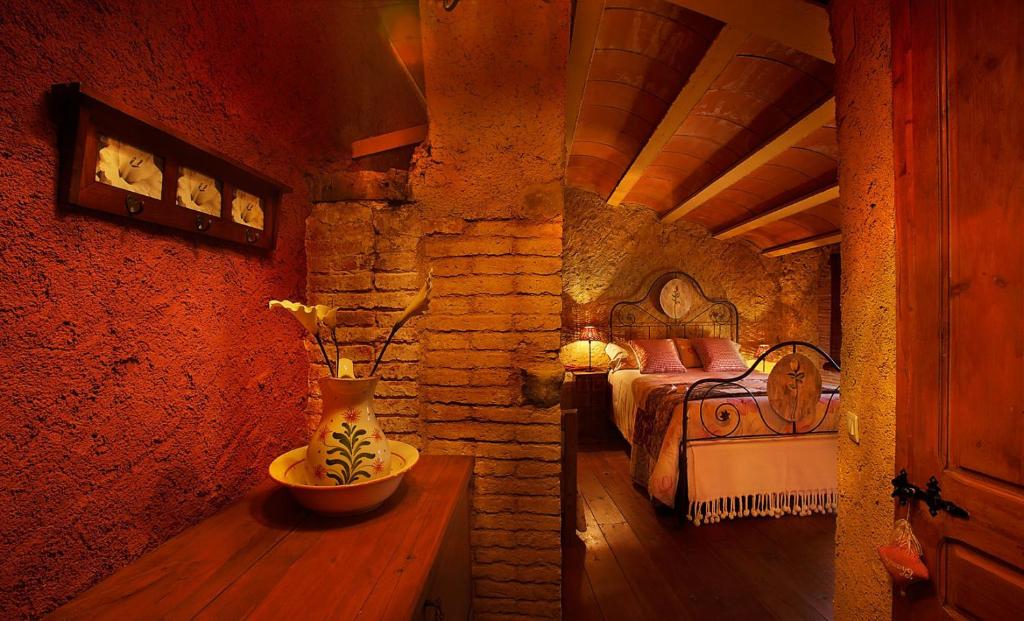 科尔努德利亚Masia El Canalot - Molí Del Pont的一间卧室,配有一张床和一张桌子上的花瓶