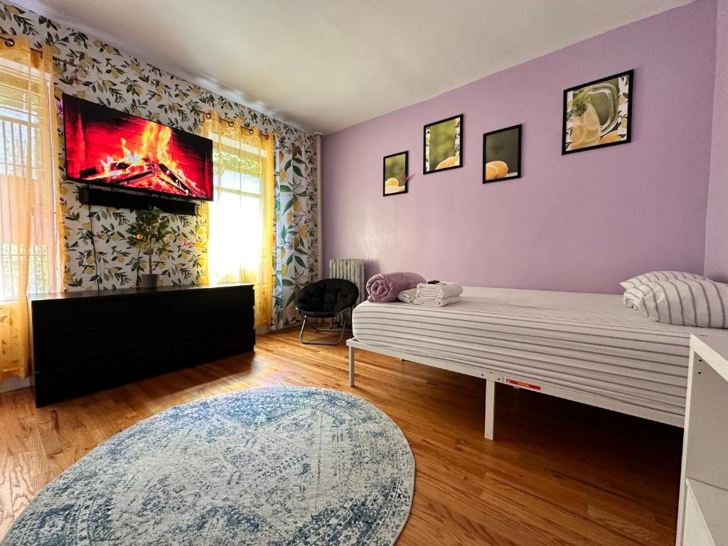 纽约Italian style room shared bathroom的一间卧室配有一张床,墙上配有电视