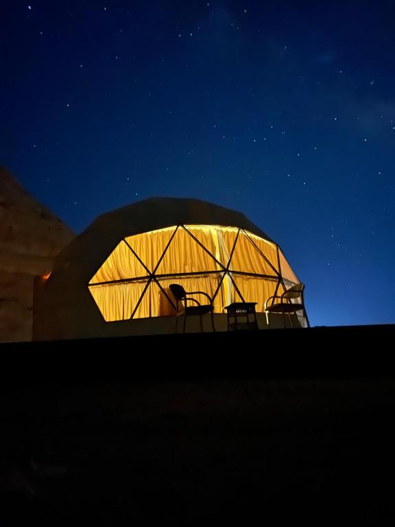 瓦迪拉姆Moon Magic Valley的圆顶形的建筑,晚上有椅子