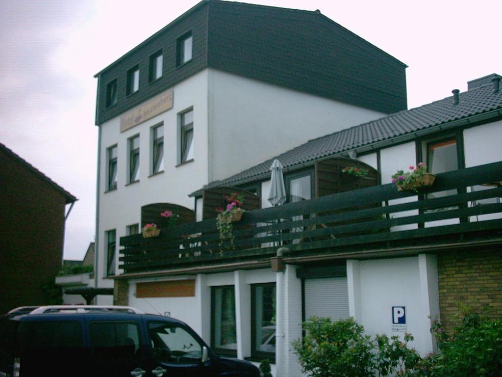 克莱沃Hotel Schwanenburg的前面有停车位的建筑