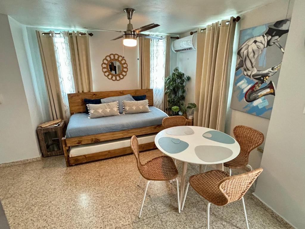 圣胡安Bee Inn Puerto Rico Charming Urban Apartment in San Juan的卧室配有一张床和一张桌子及椅子