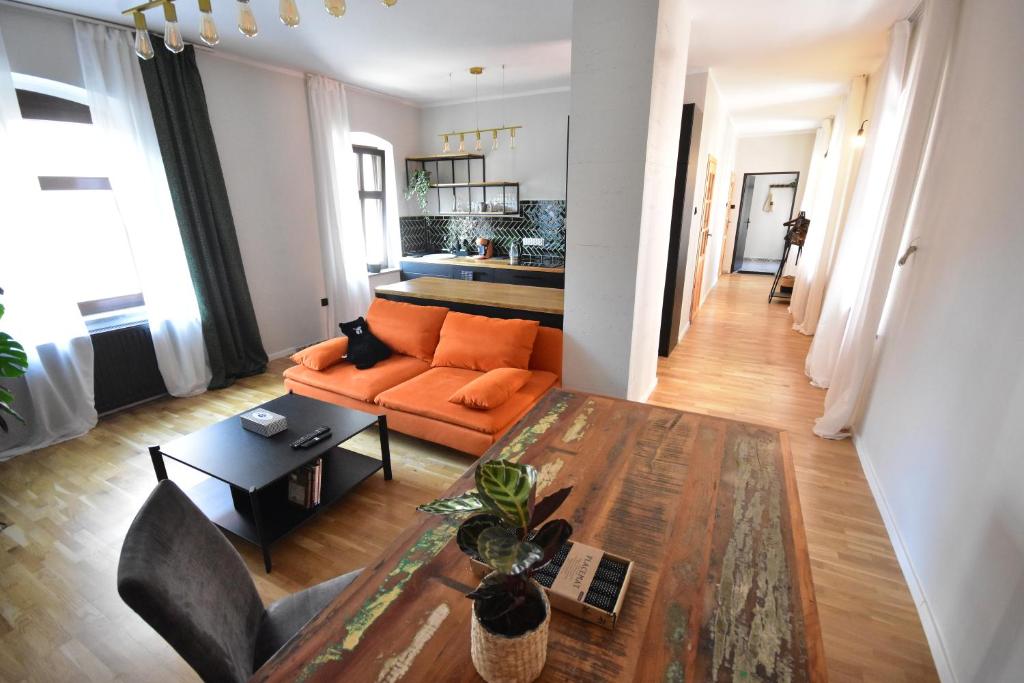 西维德尼察Apartamenty Basztowa的客厅配有橙色沙发和桌子