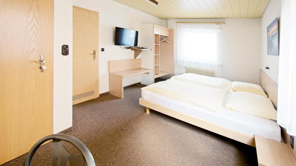莱茵河畔威尔维多利亚酒店的卧室配有白色的床和电视。