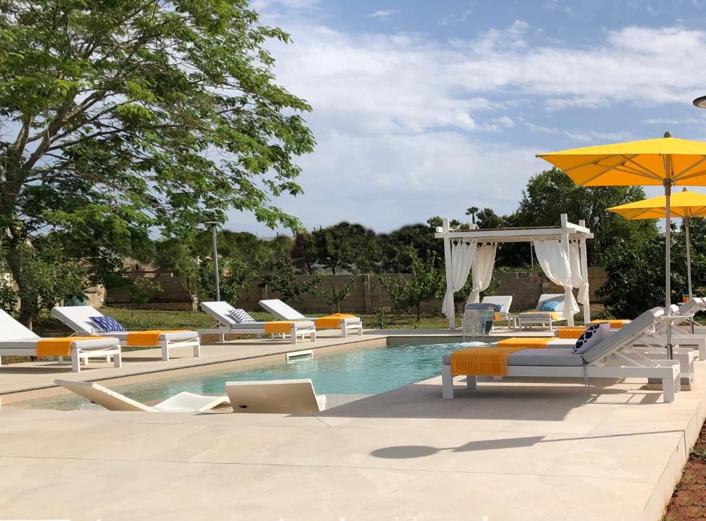 斯佩基亚B&B Casa Karina Pool&Rooms的一个带躺椅和遮阳伞的游泳池