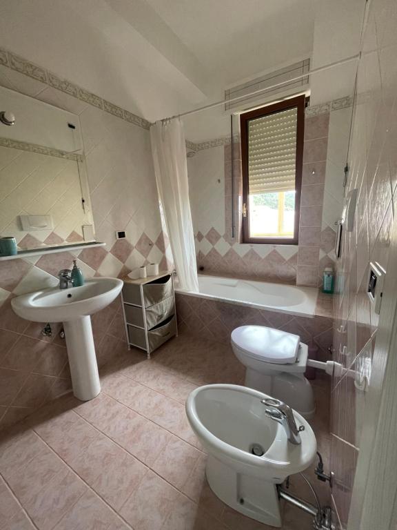 圣乔瓦尼·罗通多Heaven's Door的浴室配有盥洗盆、卫生间和浴缸。